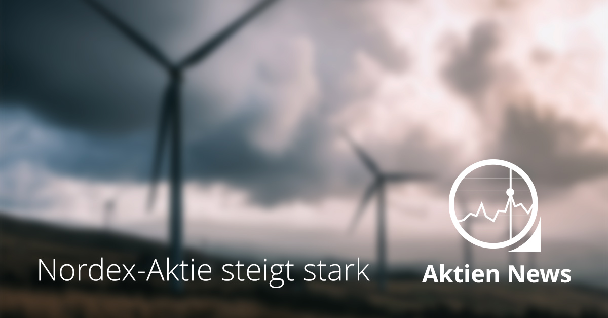 Symbolbild mit Windkraftanlagen unter wolkigem Himmel und der Aufschrift „Nordex-Aktie steigt stark“, steht für Kursanstieg nach Anhebung der Gewinnprognose und starkem Quartal.
